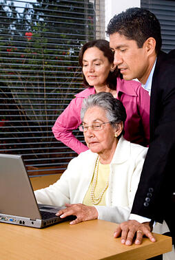 Adult children helping their elderly mother set up online accounts