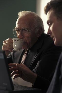 Young man on a laptop explaining care options to an elderly relative
